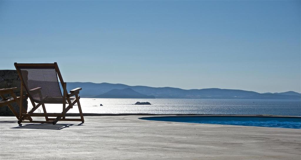 een stoel op het strand naast het water bij Naxos Aigli Villas-Master villa in Naxos Chora