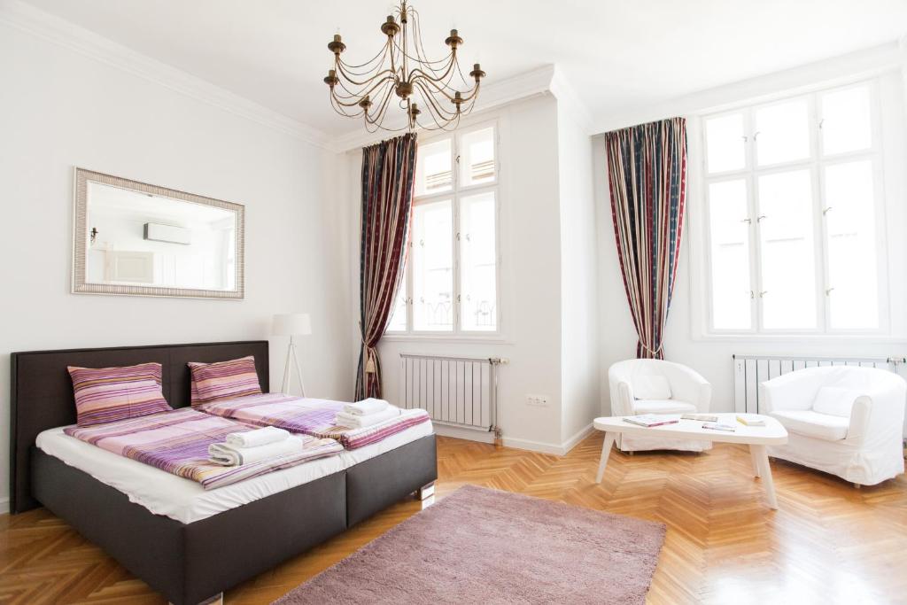 sypialnia z łóżkiem i żyrandolem w obiekcie Chic & Charm Apartment w Budapeszcie