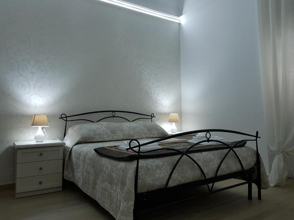 una camera con un letto e un comodino con due lampade di B&B da Mammina a Taranto
