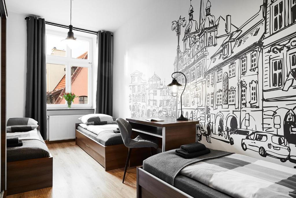 sypialnia z 2 łóżkami i biurkiem w obiekcie Prestige Apartments 7 we Wrocławiu