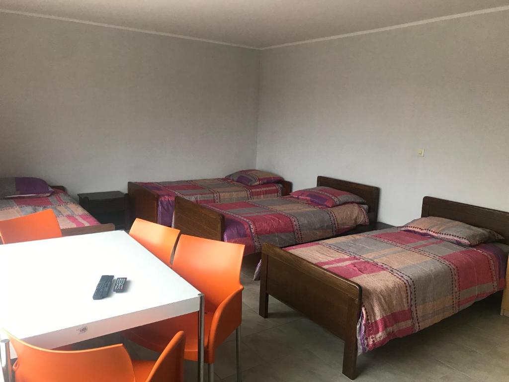 a room with four beds and a table and chairs at Pension JuRa in Gronau