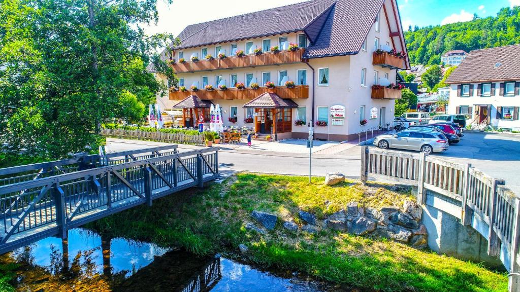 a bridge over a river in front of a building at Hotel Restaurant Schwörer in Lenzkirch