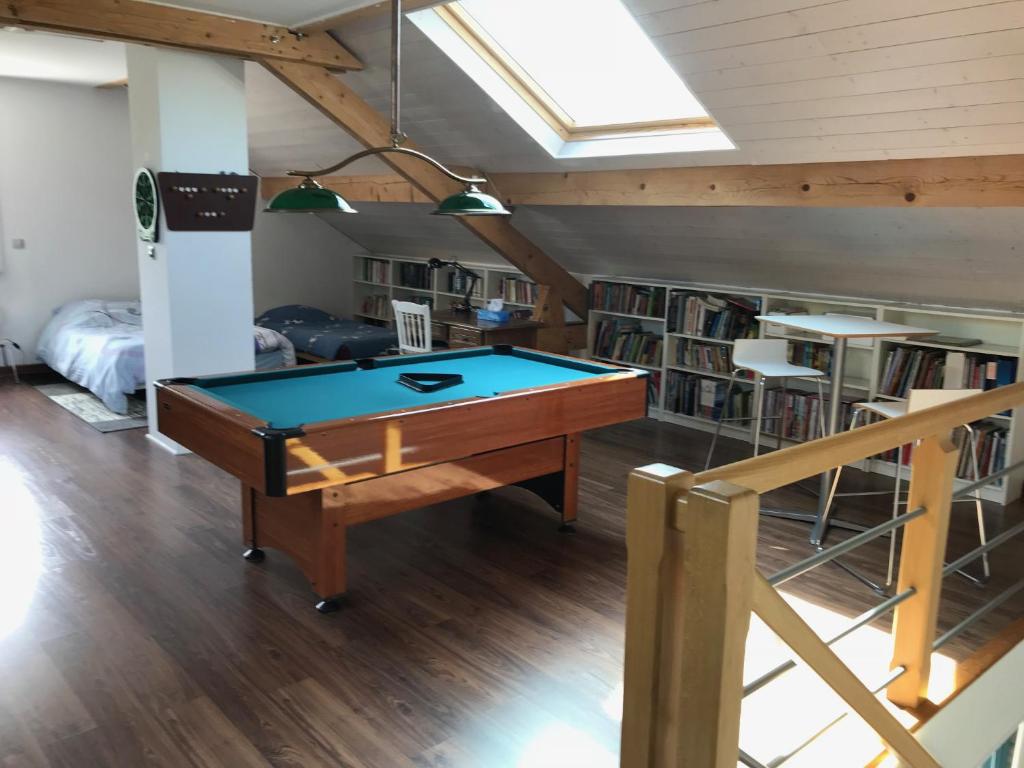 eine Tischtennisplatte in einem Zimmer mit Bücherregal in der Unterkunft Chez Fabienne in Peyrieu