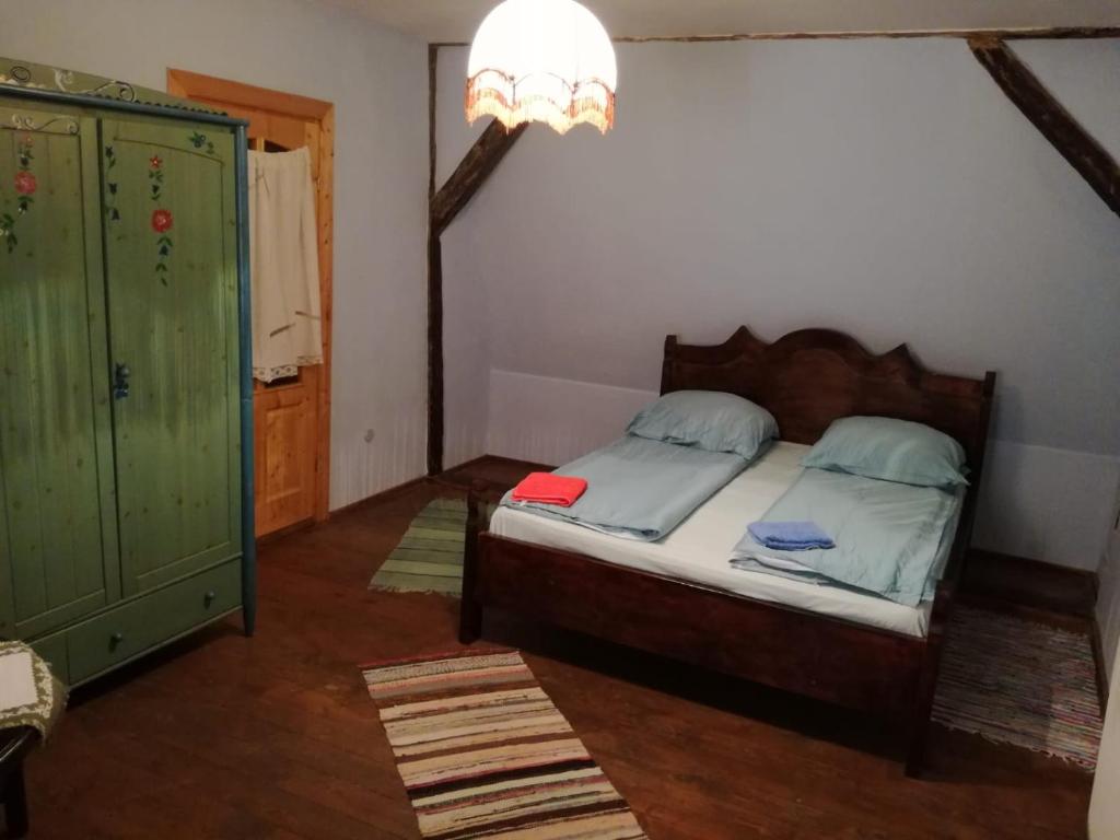 シビウにあるBlue Houseのベッドルーム1室(ベッド1台付)、緑のキャビネットが備わります。