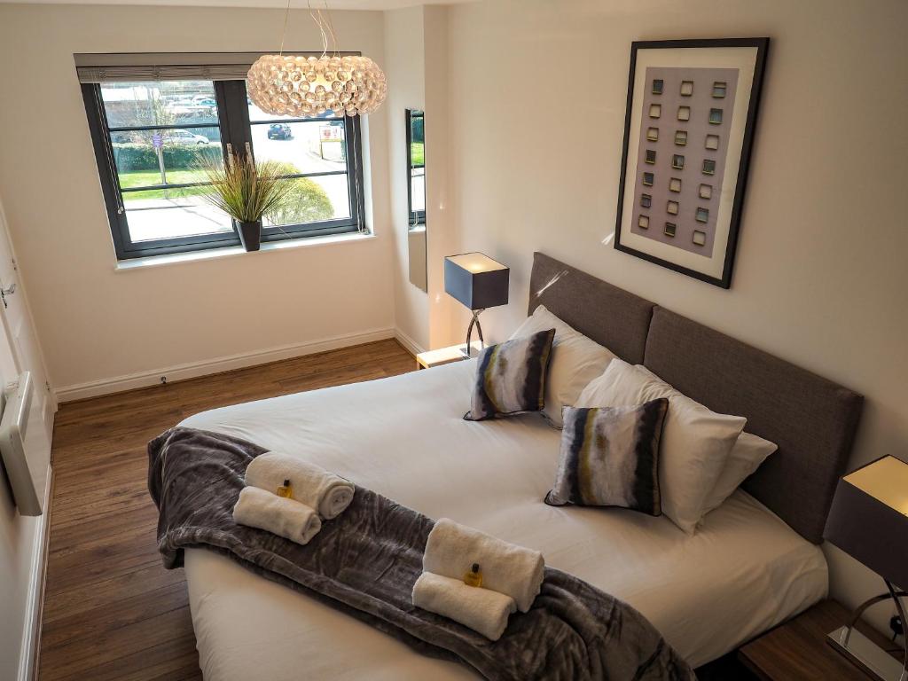 a bedroom with a large bed with two pillows at Stylish Spacious Apartment with Free Parking in Farnborough