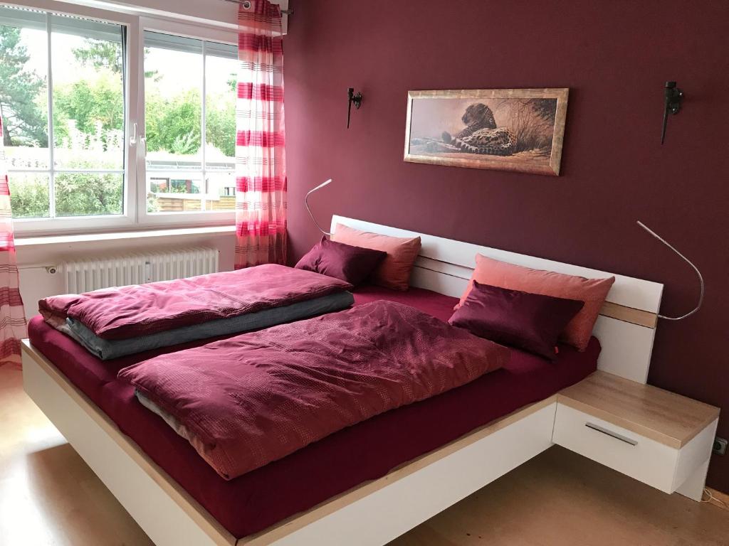 Un dormitorio con una cama con sábanas rojas y una ventana en First Floor Olching, en Olching