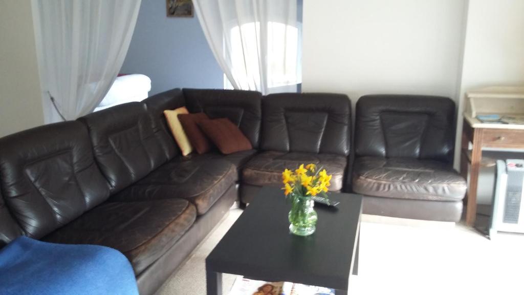uma sala de estar com um sofá e uma mesa com flores em Villa Rosa em Saint-Georges-sur-Cher