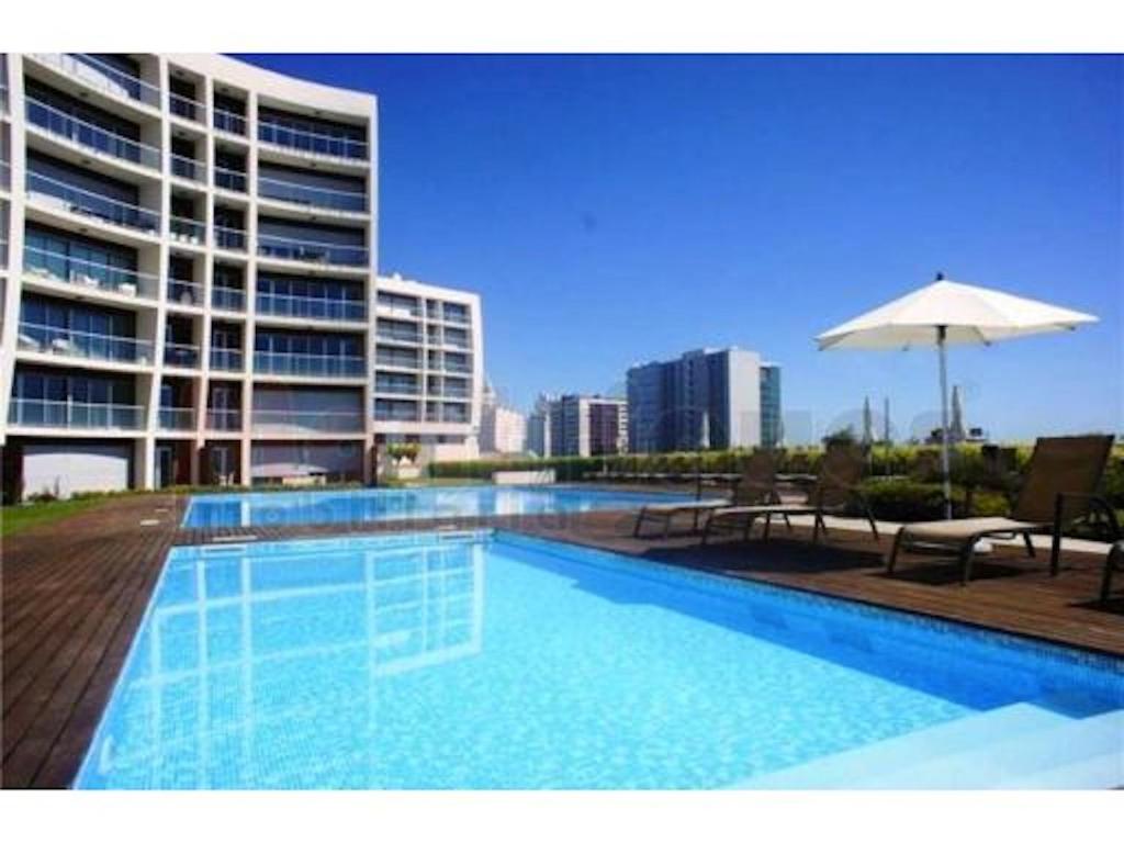 a swimming pool in front of a large building at Charming Apartment with Balcony & Pool in Lisbon