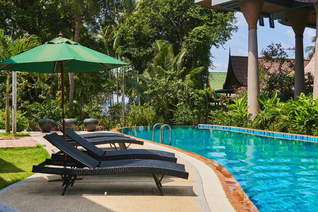 
a park bench sitting next to a swimming pool at Seaflower Bungalows in Srithanu

