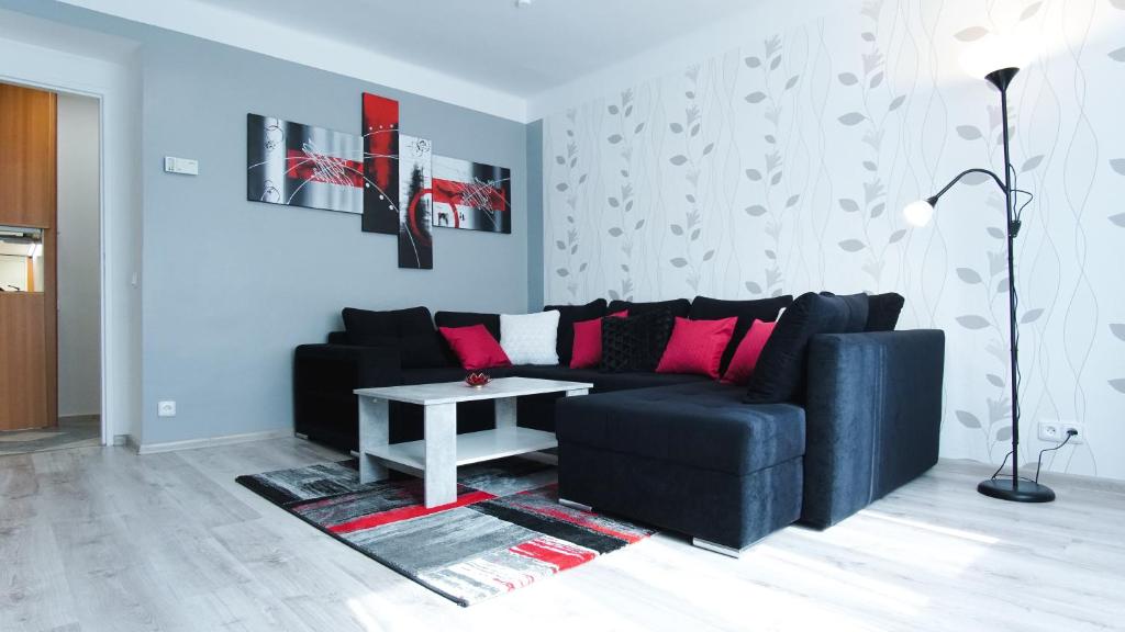 a living room with a black couch and a table at Apartmány Monty in Karlovy Vary