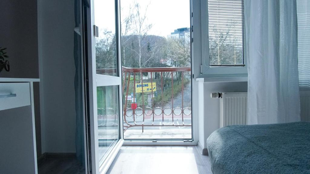 a bedroom with a door open to a balcony at Apartmány Monty in Karlovy Vary
