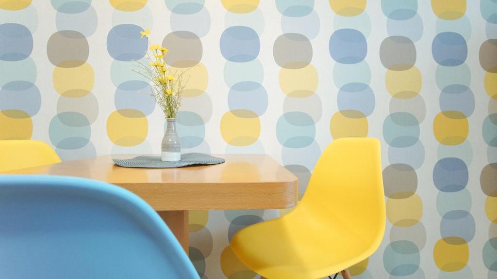 a dining room table with a vase of flowers and chairs at Apartmány Monty in Karlovy Vary