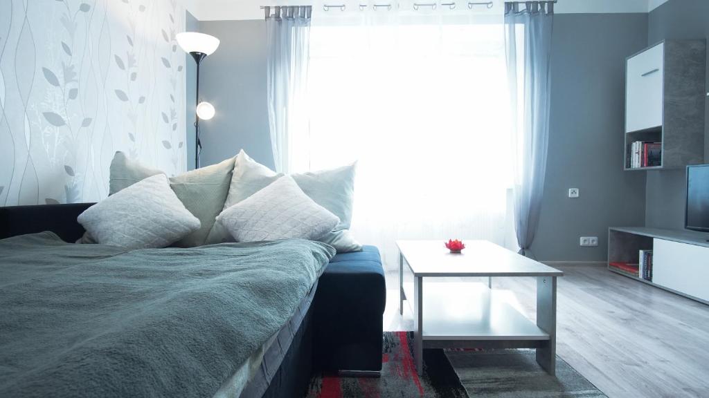 a bedroom with a bed and a table and a window at Apartmány Monty in Karlovy Vary