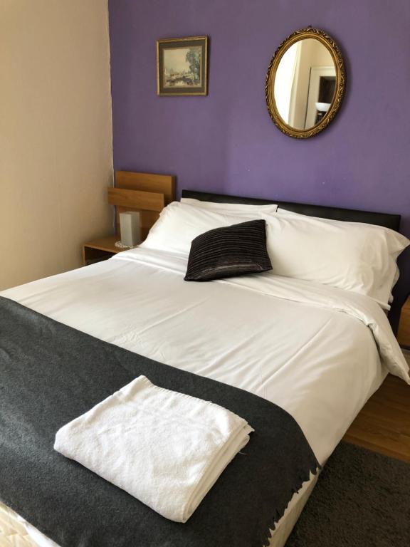 a bed with a white comforter and pillows in a room at Counan Guest House in Edinburgh