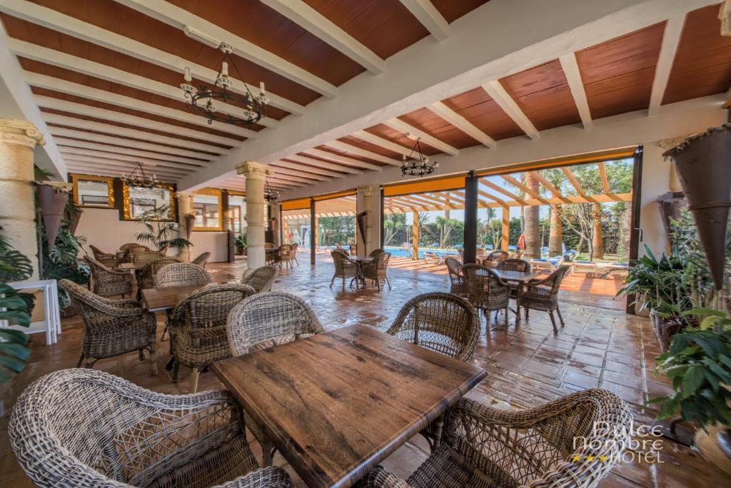 a dining room with a wooden table and chairs at Dulce Nombre Hotel - Apartamentos in Tarifa