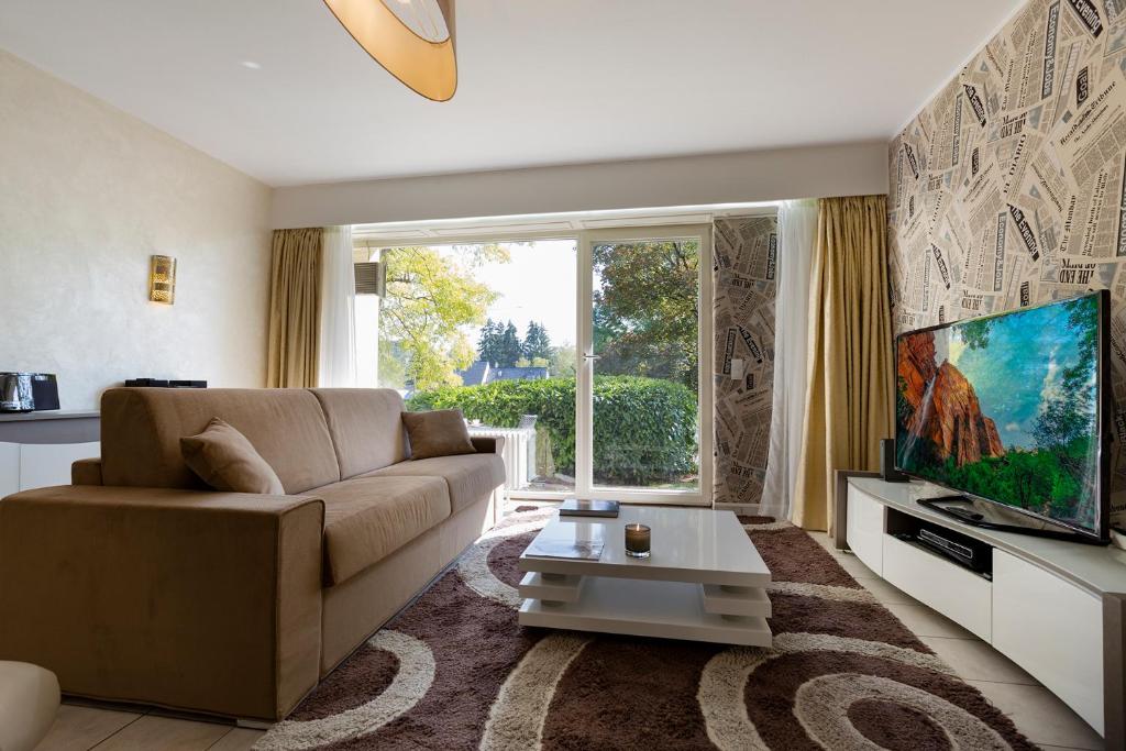 a living room with a couch and a television at Villa Canterbury in Luxembourg