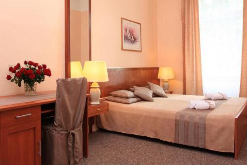 een slaapkamer met een bed en een bureau met een spiegel bij Hotel Arche in Berlijn