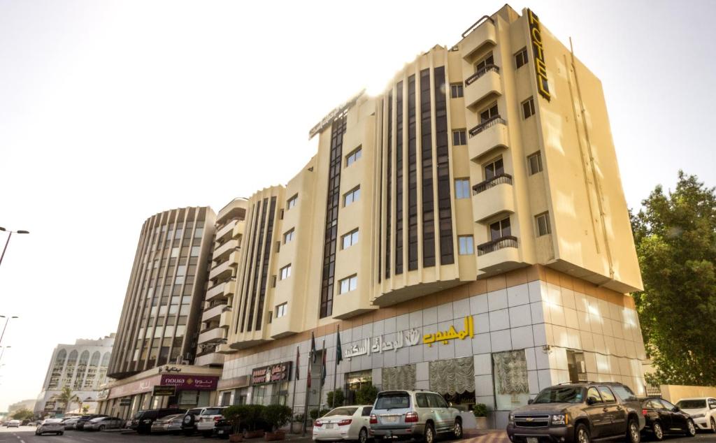 un gran edificio con coches estacionados frente a él en Al Muhaidb Palastine - Jeddah en Yeda