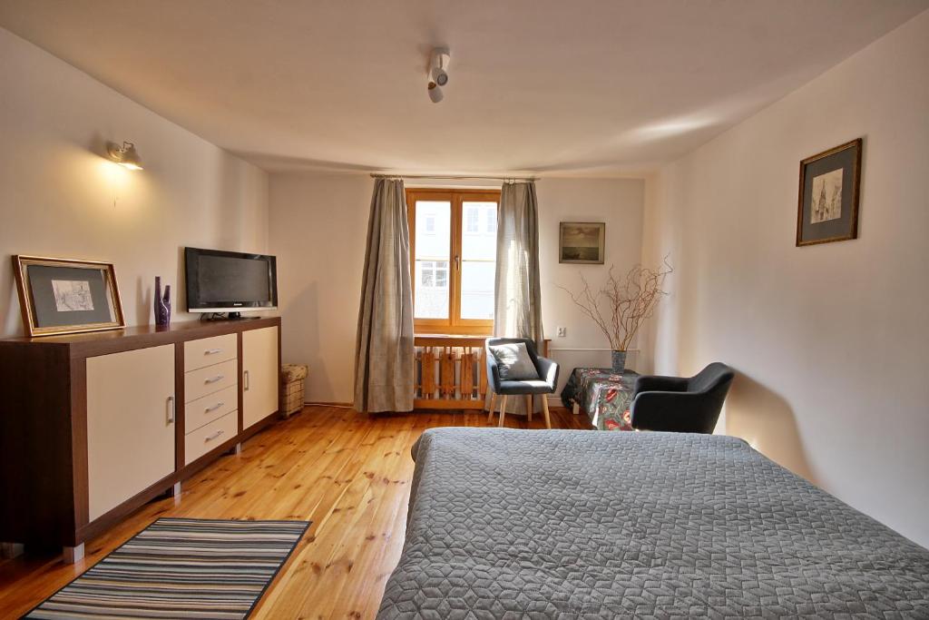 a bedroom with a bed and a dresser and a television at Bałtycki Apartament in Sopot