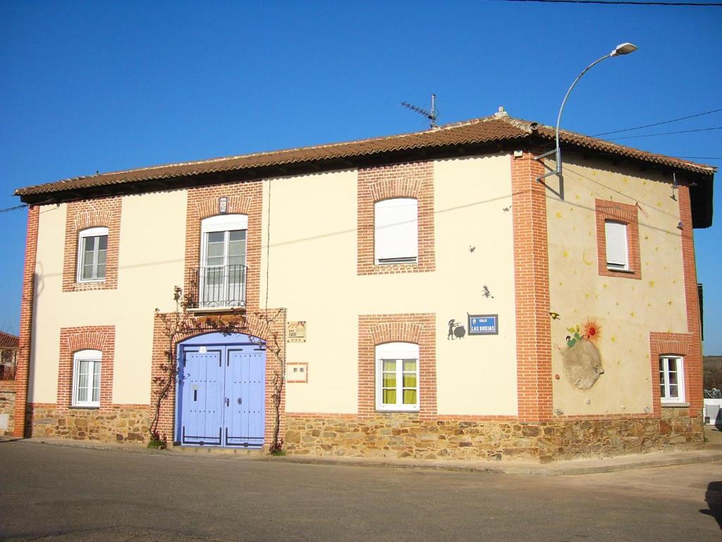 Hotel Rural La Rosa de los Tiempos في Carneros: مبنى من الطوب القديم مع باب أزرق