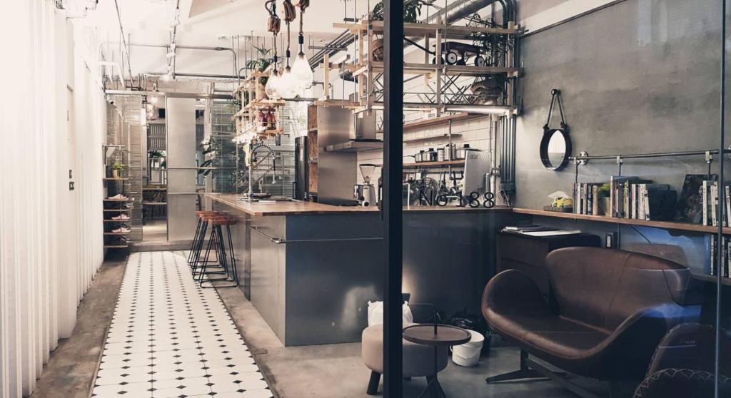 a kitchen with a counter and chairs in a room at 188 Station in Tainan