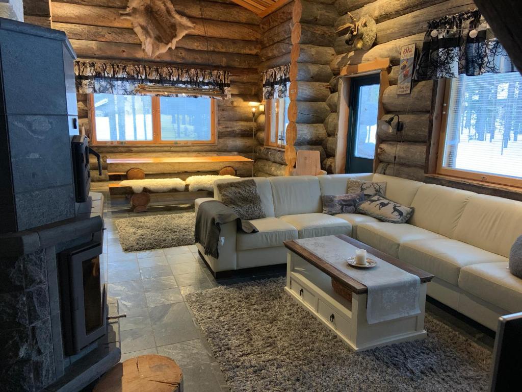 una sala de estar con sofás y una chimenea en una cabaña de madera. en Casa Levi Luxury Chalet, en Levi