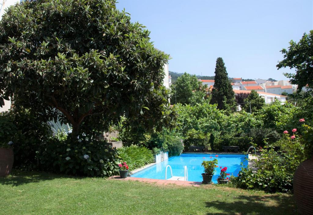 a swimming pool in a yard with trees and plants at Casa Das Obras in Manteigas