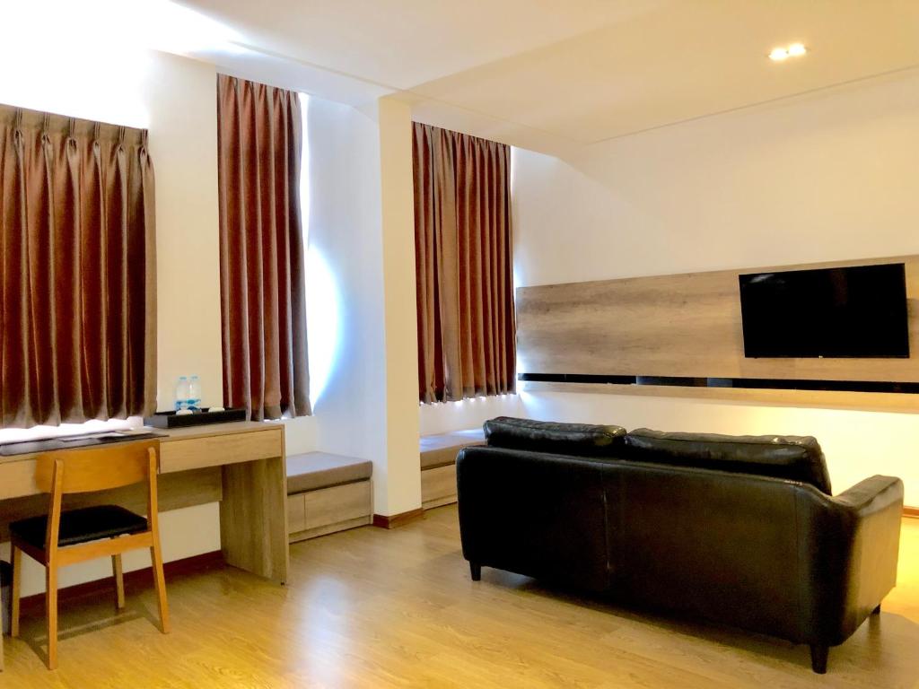 un soggiorno con un divano e un tavolo di K.C Hotel a Yangon