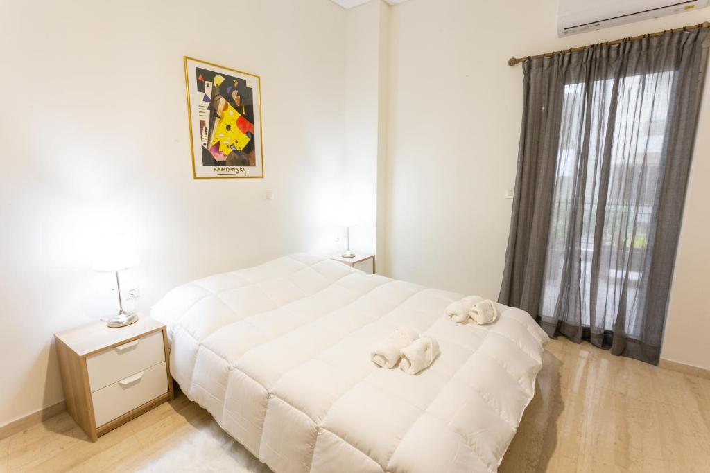 a bedroom with a white bed with stuffed animals on it at Cloud 3 Apartment in Kalamata