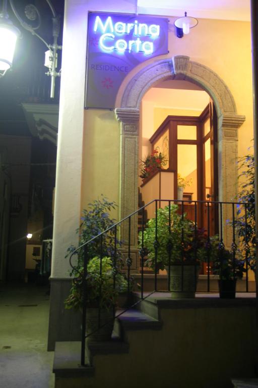 a sign on the side of a building with potted plants at Residence Marina Corta in Lipari