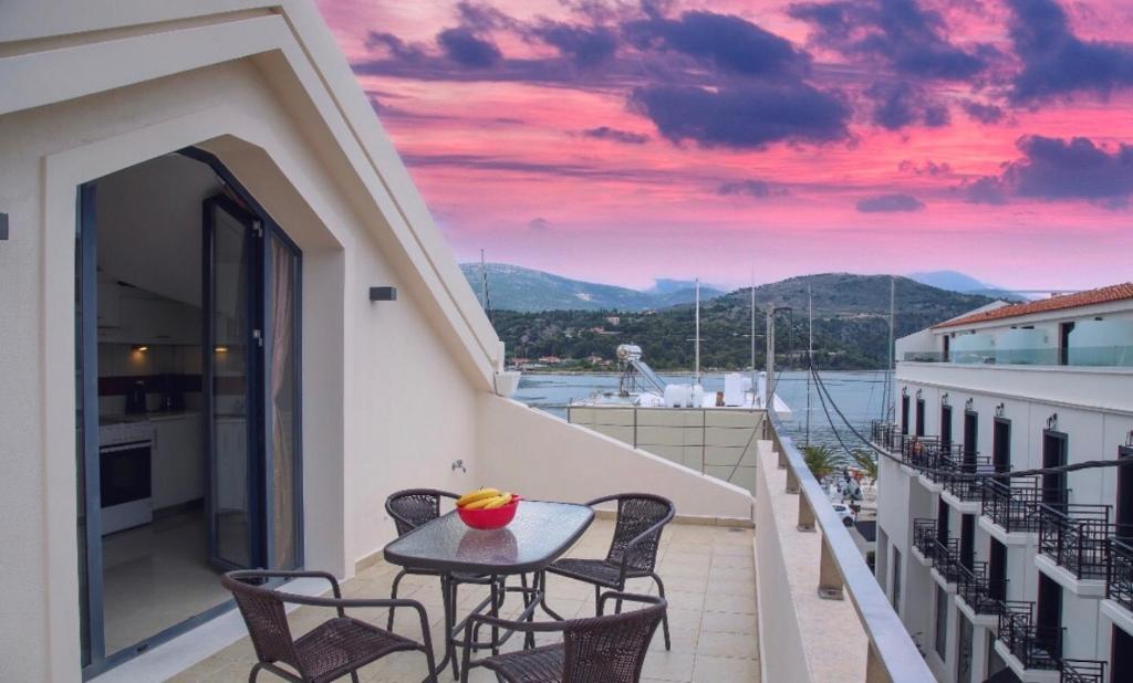 a balcony with a table and chairs and a sunset at Sophia Central Loft & Apartments in Argostoli