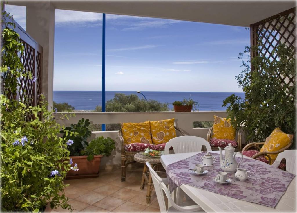 a patio with a table and chairs and a view of the ocean at Casa Pireddu in Cala Gonone
