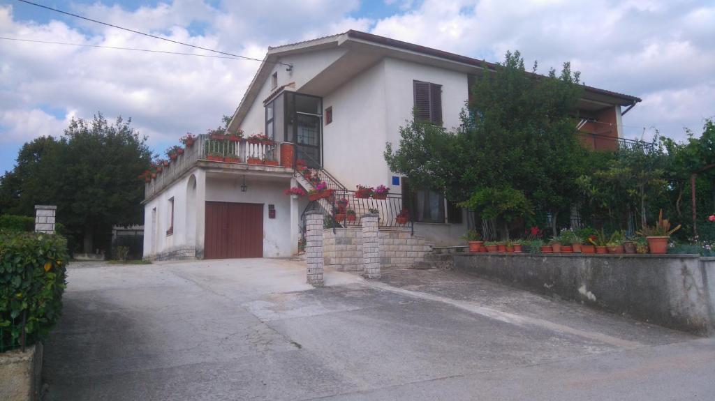 a small white house with a balcony on a street at Apartman Dino in Roč