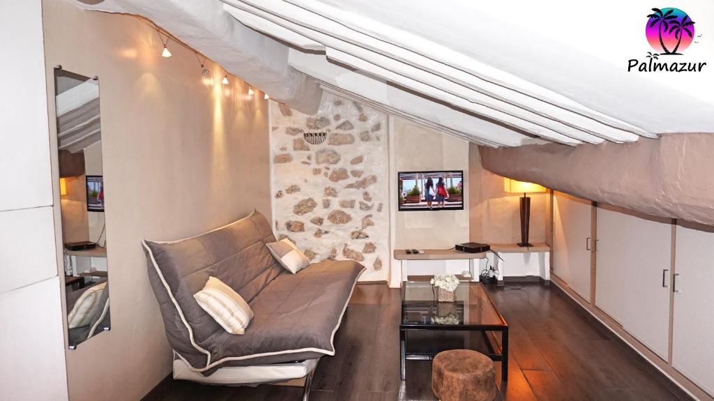 ein Wohnzimmer mit einem Sofa und einem Tisch in der Unterkunft Studio Centre Cannes By Palmazur in Cannes