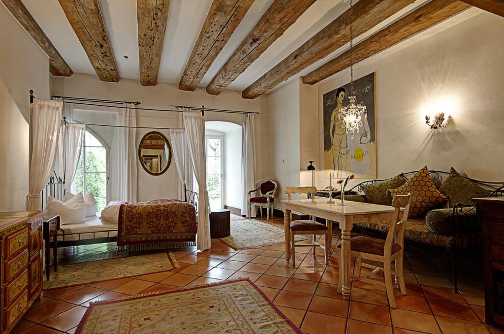 ein Wohnzimmer mit Tisch und Couch in der Unterkunft Hotel Orphée Andreasstadel in Regensburg