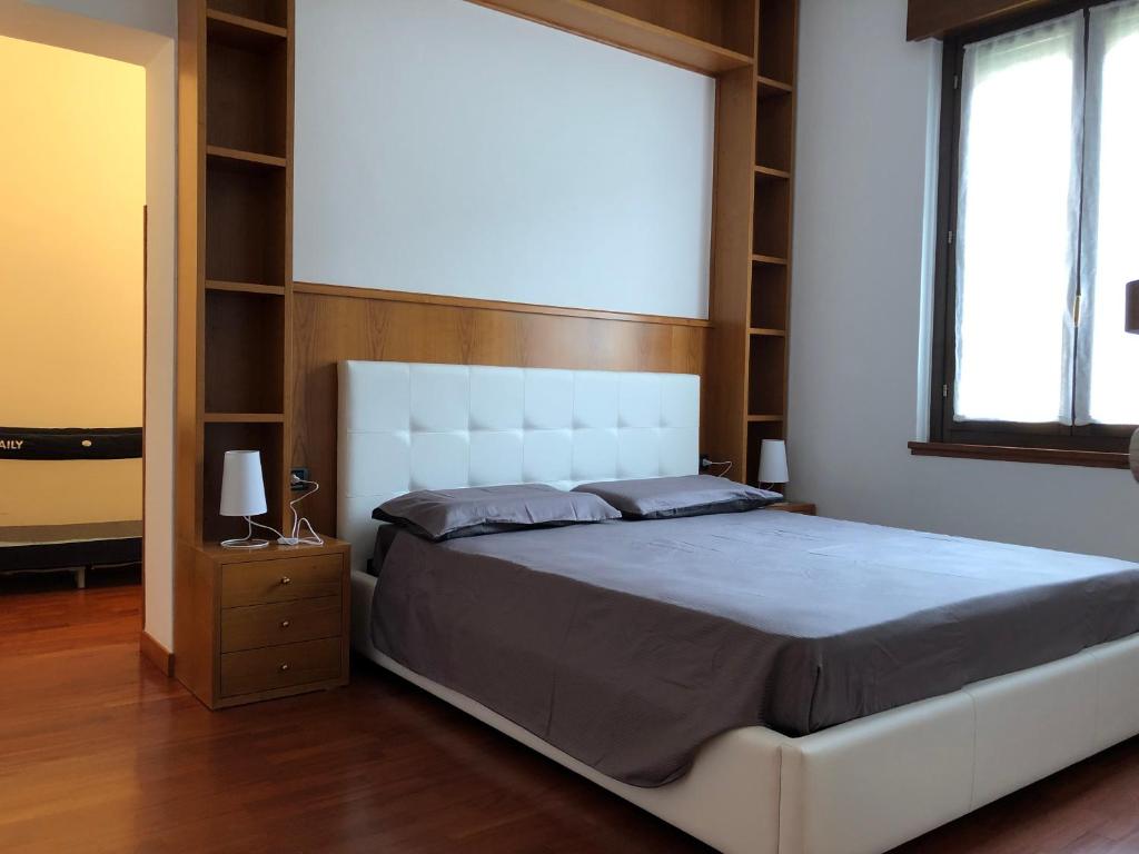 a bedroom with a large white bed and shelves at Veneto Civico 17 in Sarnico