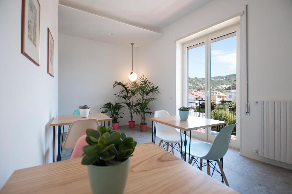 Casa27 في تيراتشينا: غرفة طعام مع طاولة وكراسي ونافذة