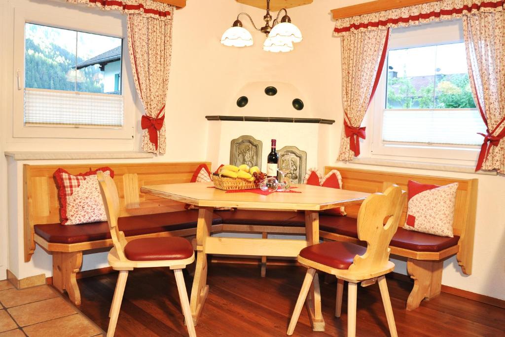 a dining room with a table and chairs and a fireplace at Appartment Maurer in Oetz