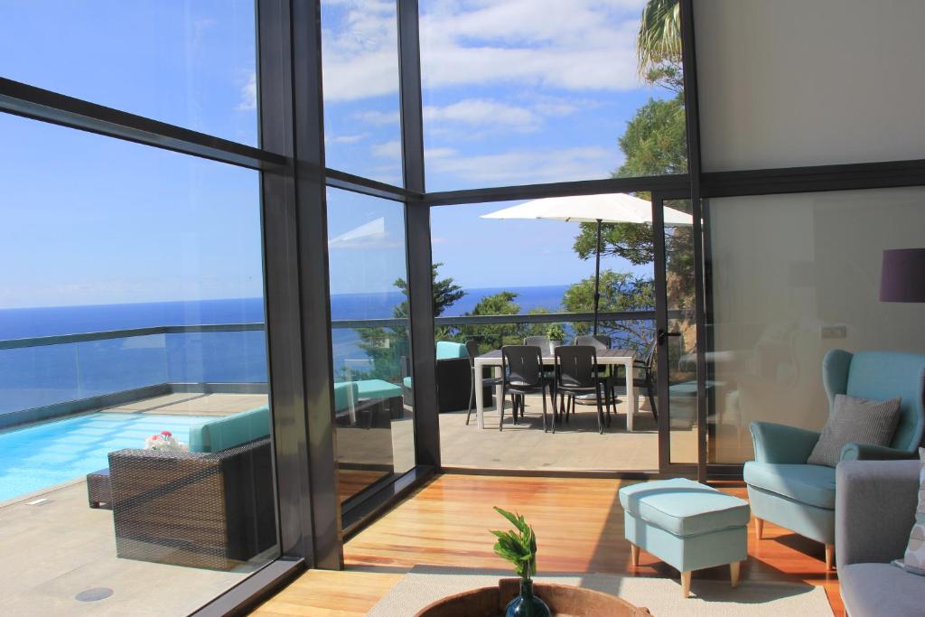 een woonkamer met uitzicht op de oceaan vanuit een huis bij Sea House Madeira in Garajau