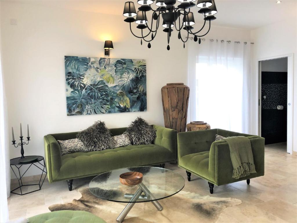 - un salon avec un canapé vert et une table en verre dans l&#39;établissement Loft Christina moderne et confortable, vue lac, climatisation, parking, à Aix-les-Bains
