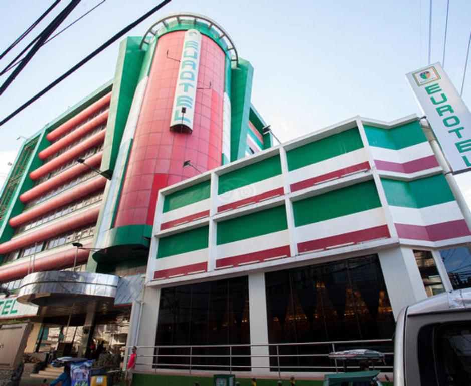 a large building with a red and green at Eurotel North EDSA in Manila