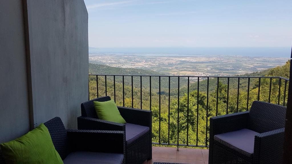 two chairs sitting on a balcony with a view at Gîte La Fontaine Corse in Loreto-di-Casinca