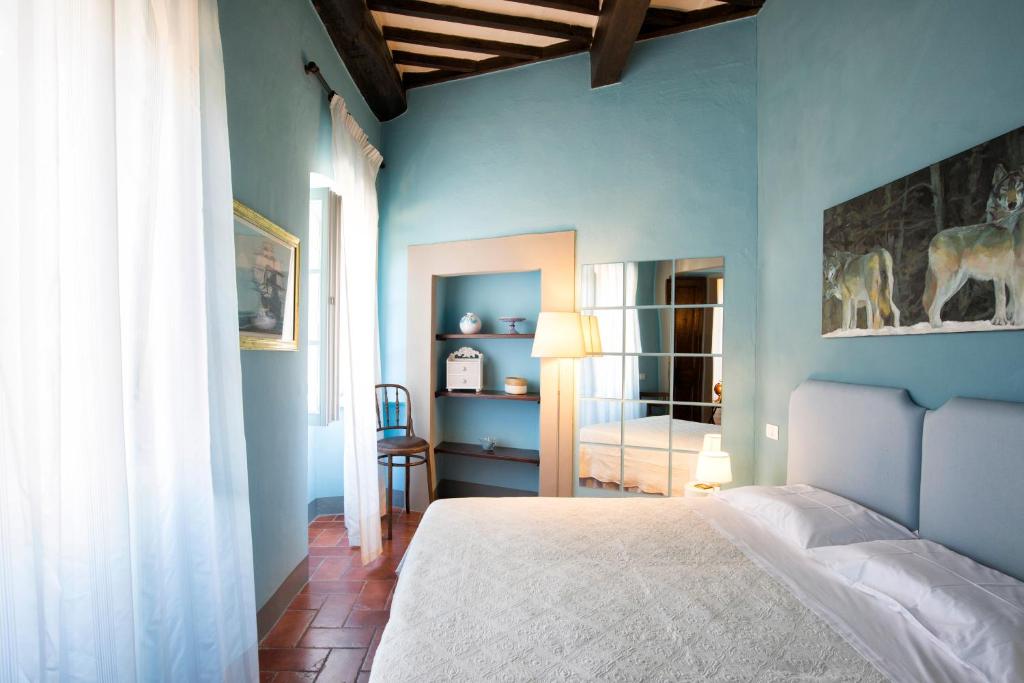 una camera con letto e parete blu di Casa del Loggiato a Cortona