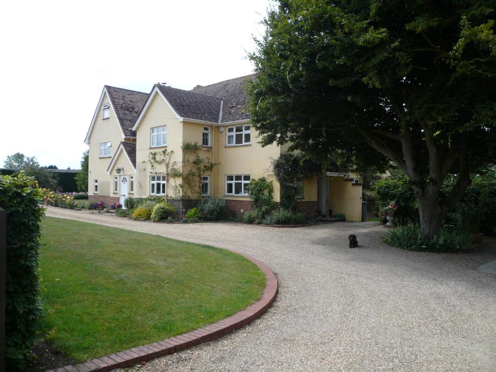 a house with a dog sitting in the driveway at The Newnham White House in Baldock