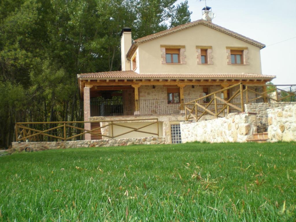 una casa con un campo verde delante de ella en Casa Rural Los Molinillos, en Caballar