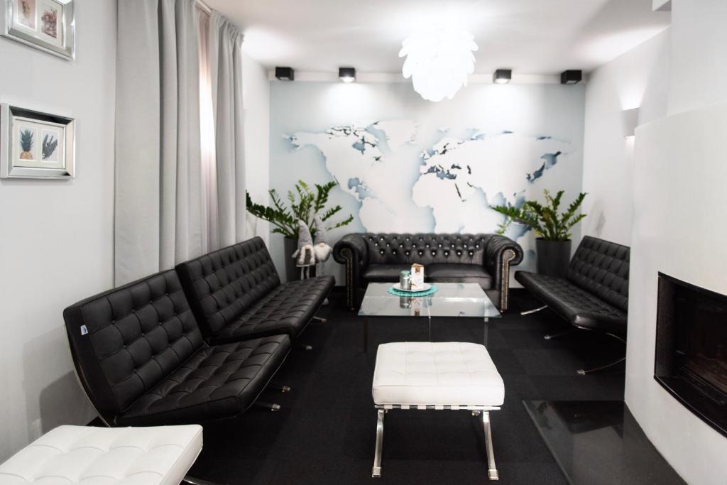 a waiting room with black leather furniture and a world map on the wall at Pause Gubin in Gubin