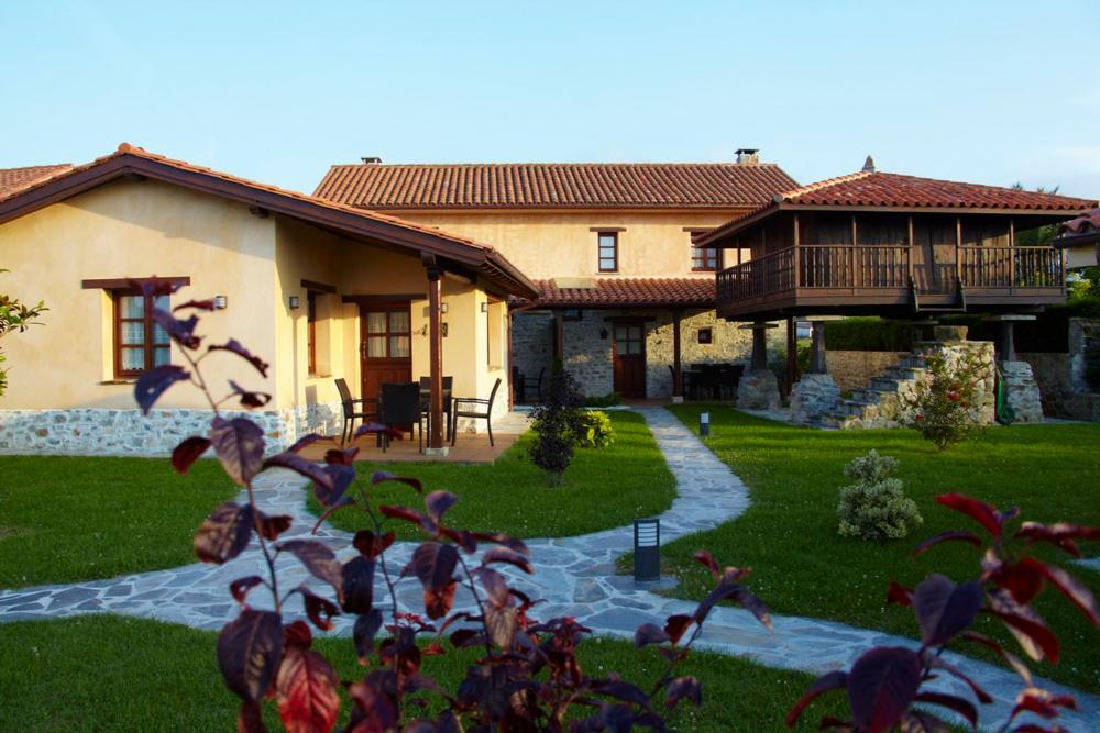 una casa grande con un patio con una casa en Casa Buelo Alojamientos Rurales, en Oviñana