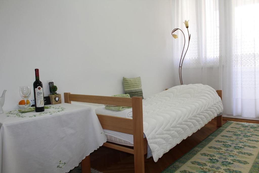 Habitación con mesa, cama y mesa con botellas de vino. en Full View, en Mostar