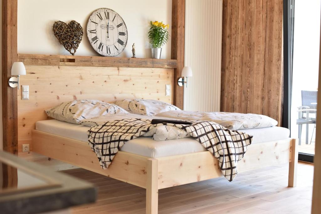Heinfling Chalet Essing في أسئينغ: غرفة نوم مع سرير مع ساعة على الحائط