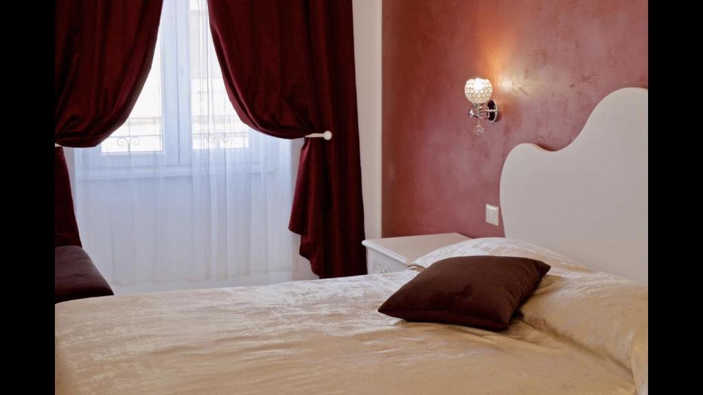 a bedroom with a bed with a pillow on it at Museum Guest House in Civitavecchia